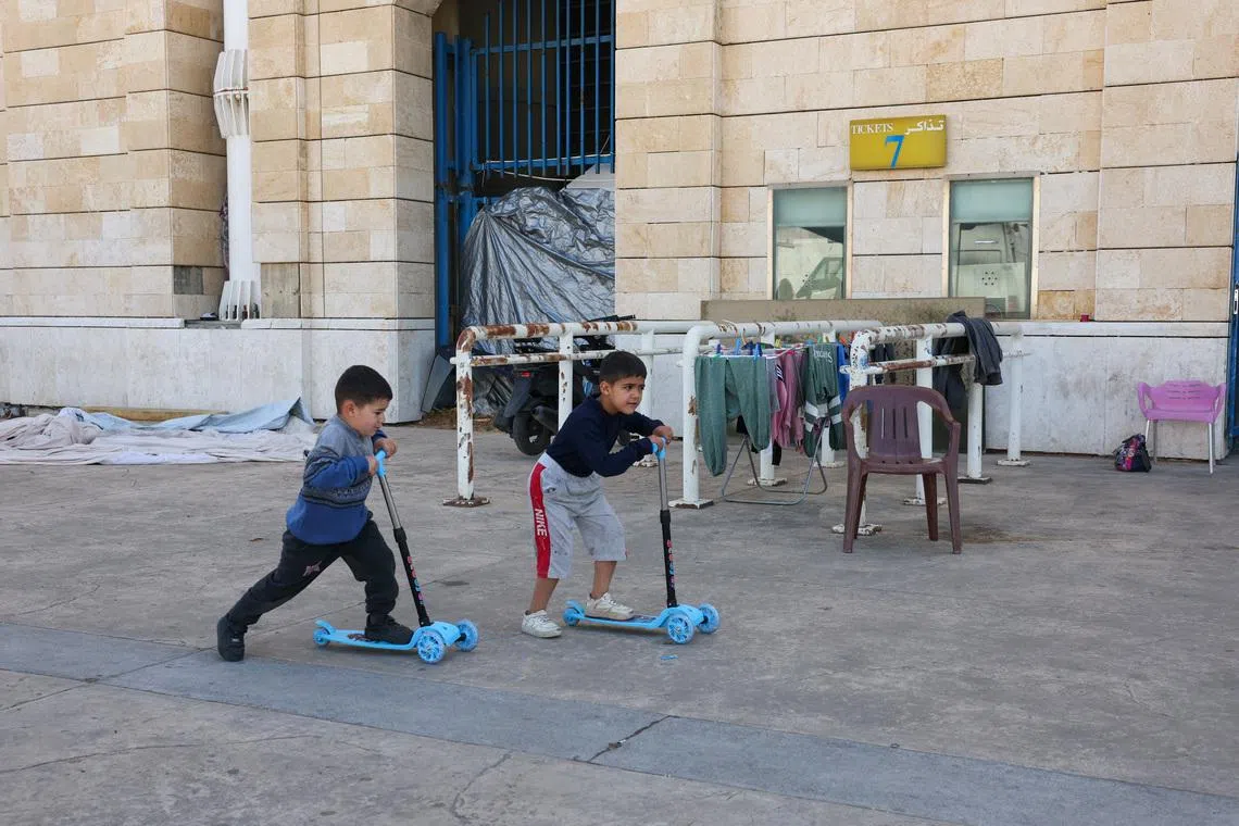 Children play outside Camille Chamoun Sports City stadium, turned into a temporary shelter in Beirut, Lebanon, May 8, 2026. REUTERS/Mohamed Azakir