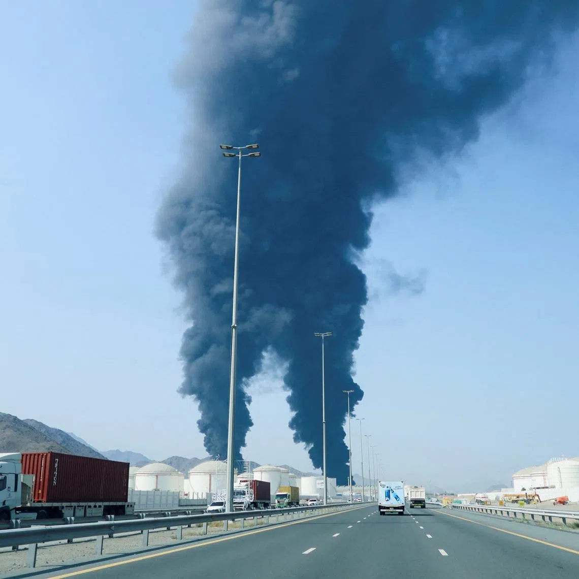 Smoke rises in the Fujairah oil industry zone, caused by debris after interception of a drone by air defenses, according to the Fujairah media office, amid the U.S.-Israel conflict with Iran, in Fujairah, United Arab Emirates, March 14, 2026. REUTERS/Staff
