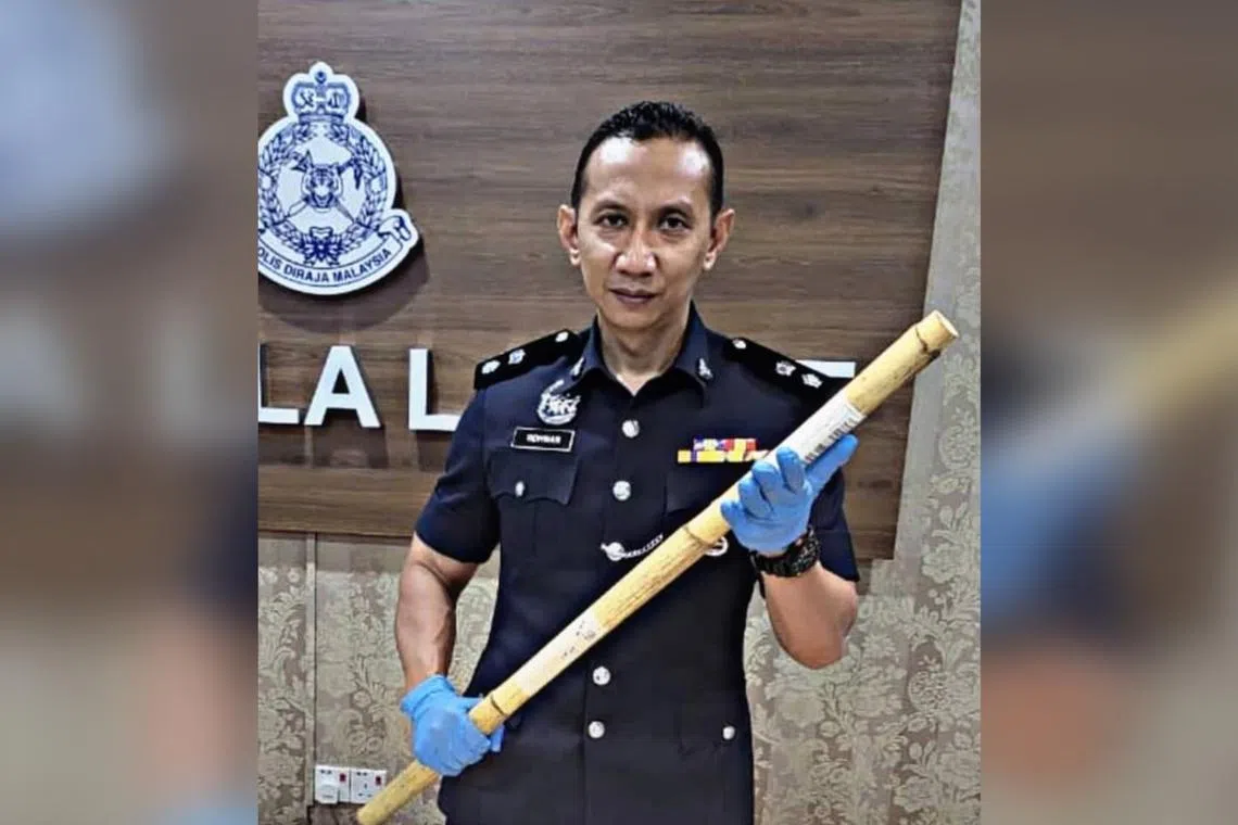 Kuala Langat district police chief Ahmad Ridhwan Mohd Nor with the cane allegedly used to assault the woman. 