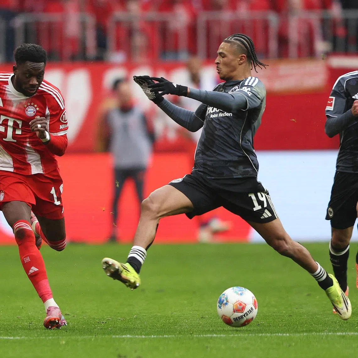 Soccer Football - Bundesliga - Bayern Munich v Eintracht Frankfurt - Allianz Arena, Munich, Germany - February 21, 2026 Bayern Munich's Alphonso Davies in action with Eintracht Frankfurt's Jean-Matteo Bahoya REUTERS/Maryam Majd