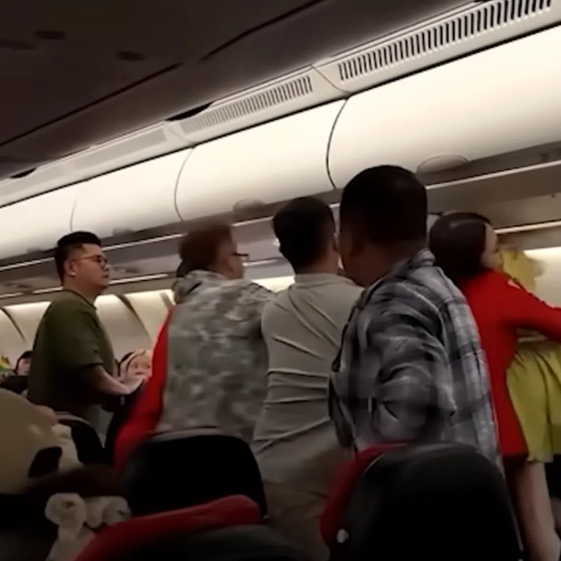 Flight attendants try to separate a man and two women having a scuffle at an AirAsia flight from Kuala Lumpur to Chengdu on July 21, 2025.