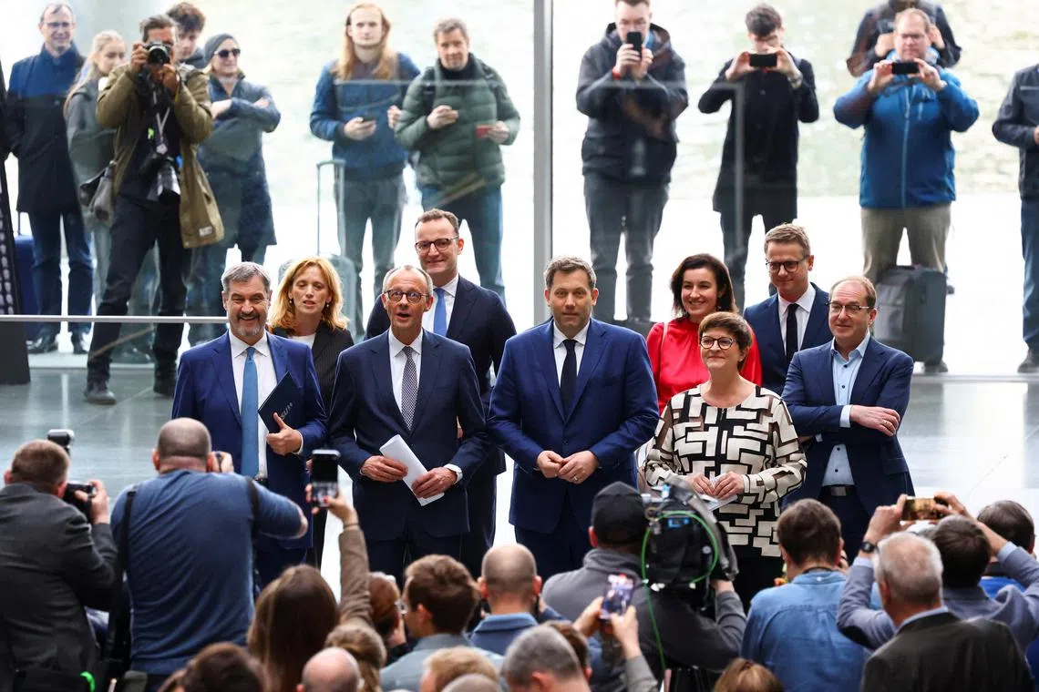 Germany's chancellor-in-waiting and leader of the Christian Democratic Union party (CDU) Friedrich Merz, Christian Social Union (CSU) leader and Bavarian Premier Markus Soeder, co-leaders of the Social Democratic party (SPD) Saskia Esken and Lars Klingbeil pose for pictures as they attend a press conference after reaching an agreement on their coalition government in Berlin, Germany, April 9, 2025. REUTERS/Fabrizio Bensch