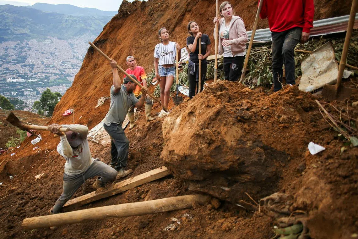Community members and rescue groups working in the area of ​​a landslide, in Bello, Colombia, on June 26, 2025. 