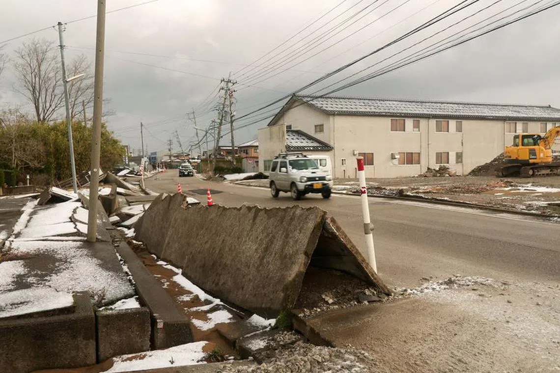 A car drives near a sidewalk damaged by the January 1 earthquake in Nishiaraya, Ishikawa Prefecture, Japan January 8, 2024. REUTERS/ Joseph Campbell