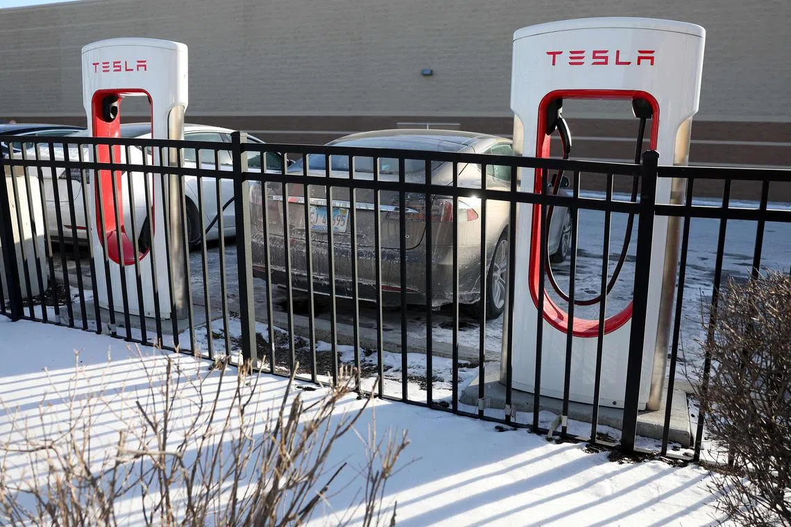 CHICAGO, ILLINOIS - JANUARY 17: Tesla vehicles charge in a snow and salt covered parking lot on January 17, 2024 in Chicago, Illinois. Recent research findings show that below-freezing temperatures reduced driving range up to 70% on 18 popular EV models, including those from Tesla.   Kevin Dietsch/Getty Images/AFP (Photo by Kevin Dietsch / GETTY IMAGES NORTH AMERICA / Getty Images via AFP)
