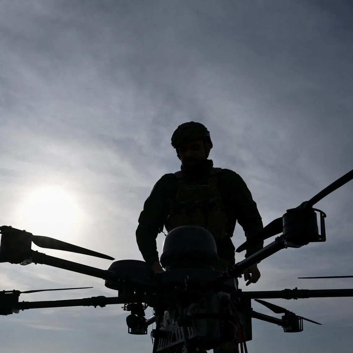 A service member of the 422nd Unmanned Systems Regiment stands next to a heavy strike drone at a training ground, amid Russia's attack on Ukraine, in Zaporizhzhia region, Ukraine March 23, 2026. REUTERS/Stringer