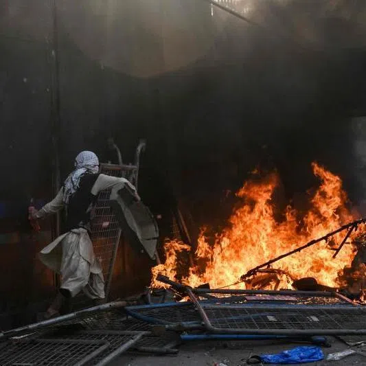 Shiite Muslims set on fire the US consulate's entrance gate in Lahore on March 1, 2026 during a protest against the death of Iran's supreme leader Ayatollah Ali Khamenei amid US-Israel strike. 