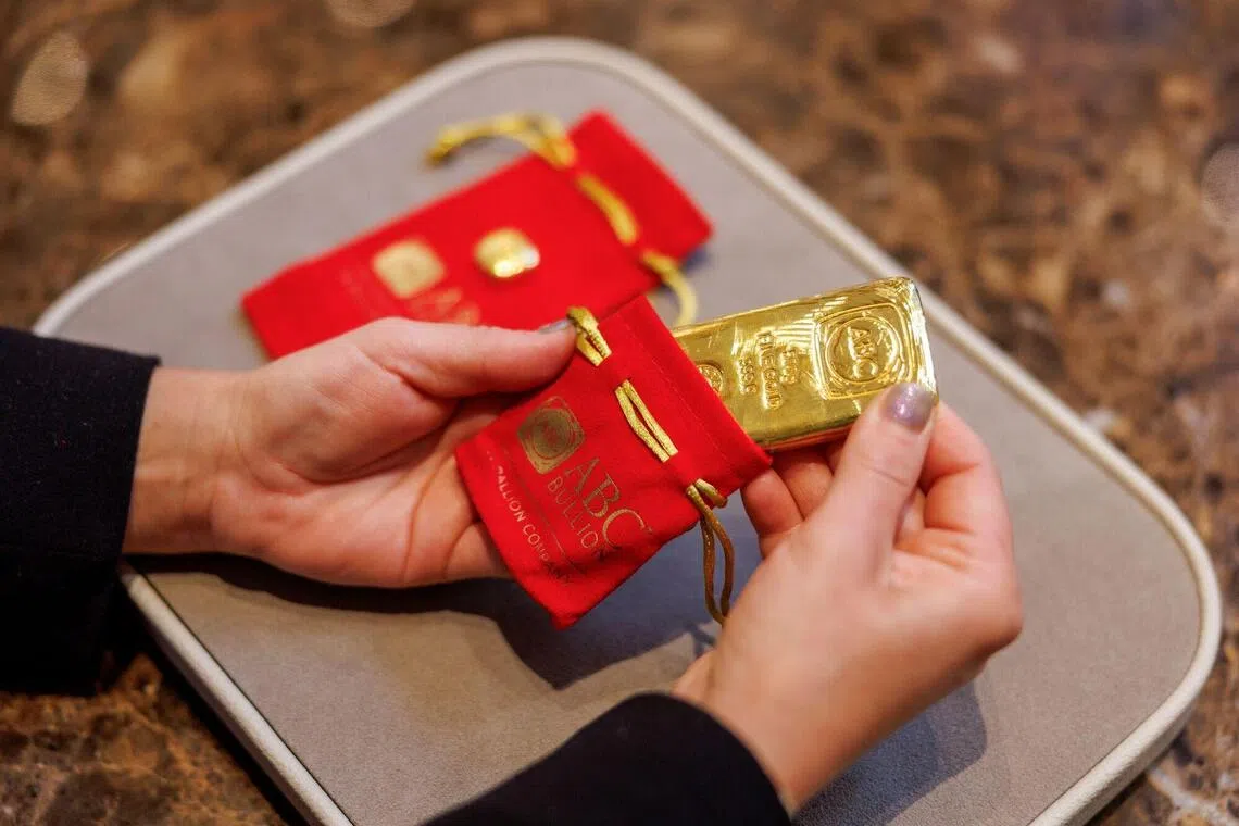 A shop assistant places a 500 gram gold bar in a protective pouch at an ABC Bullion store in Sydney, Australia, on Tuesday, Oct. 21, 2025. Gold held near a record high, finding support despite optimism global trade tensions are easing and hopes the US government will reopen soon. Photographer: Brendon Thorne/Bloomberg