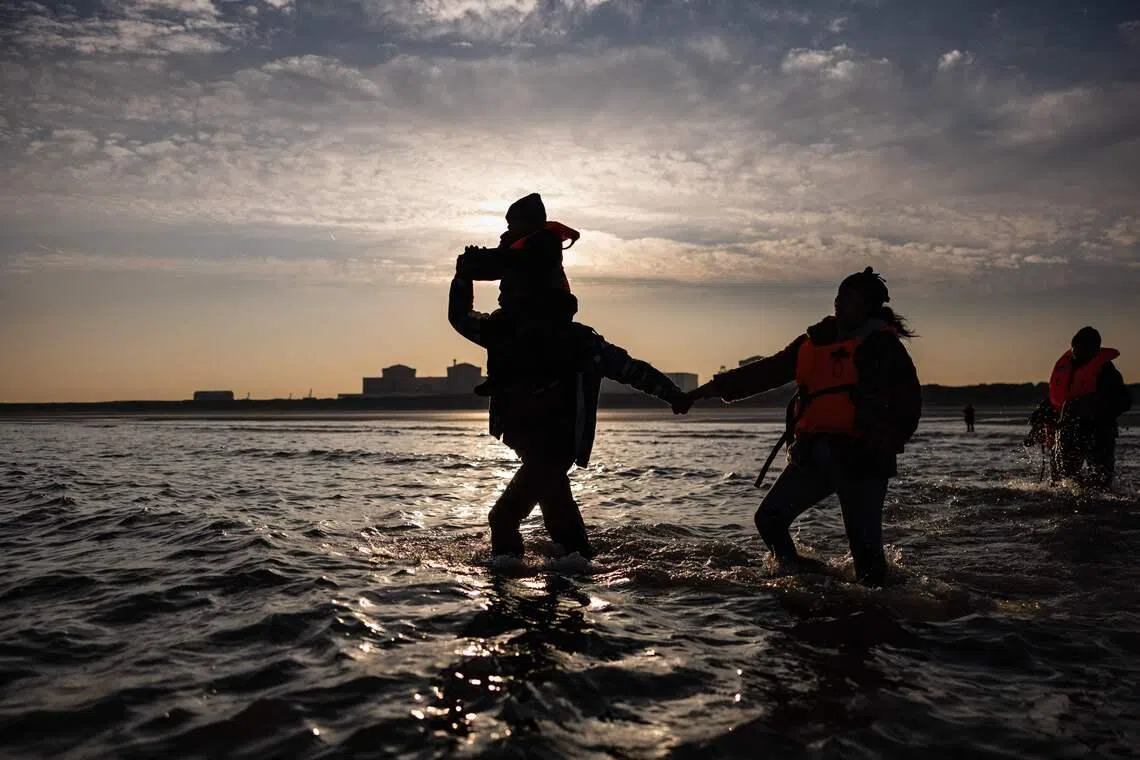 Migrants trying to board a smugglers' boat in an attempt to cross the English Channel off the beach of Gravelines, northern France, on March 3, 2026. 