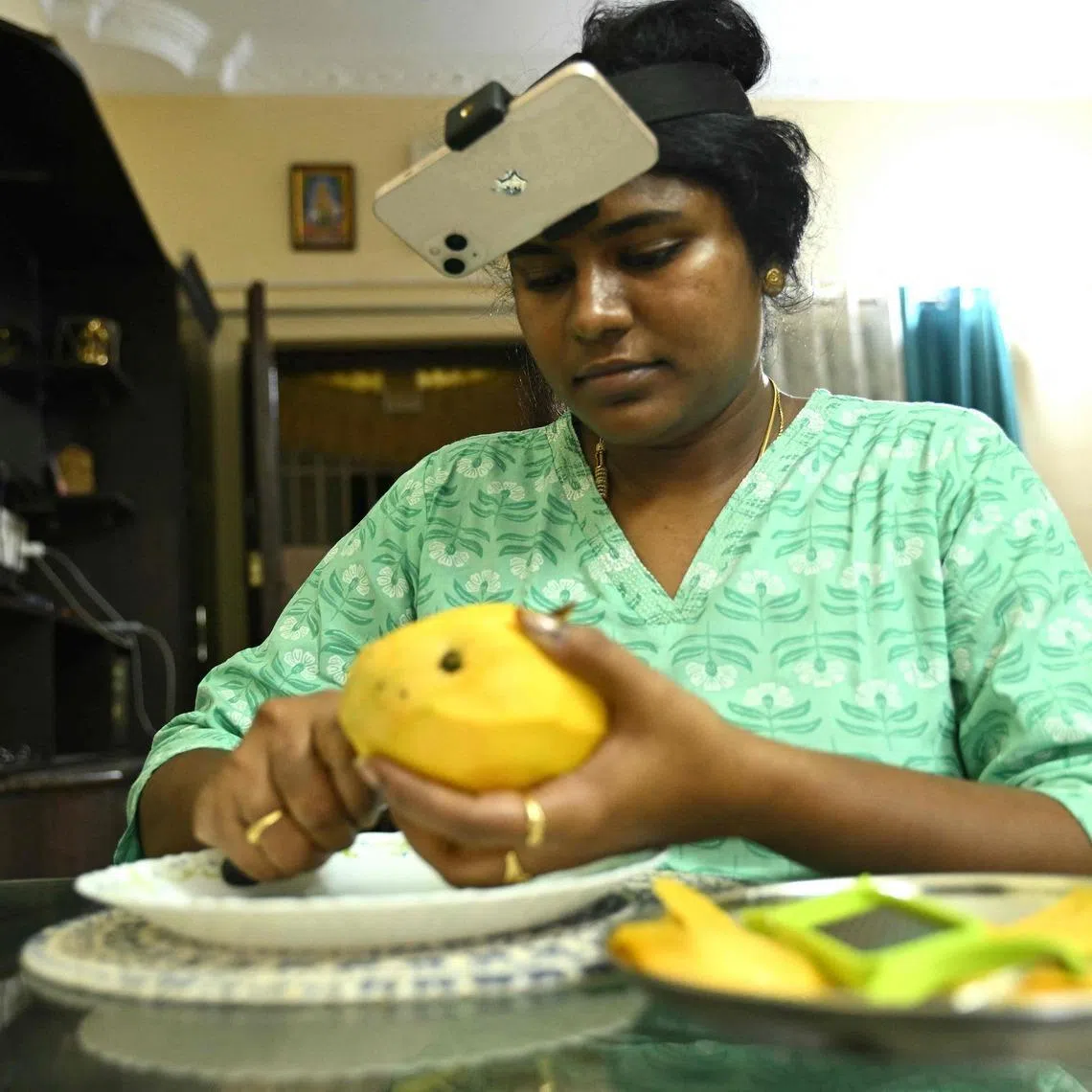 Indian housewife Nagireddy Sriramyachandra filming herself slicing mangoes to train AI-powered robots to take on household jobs in the future.