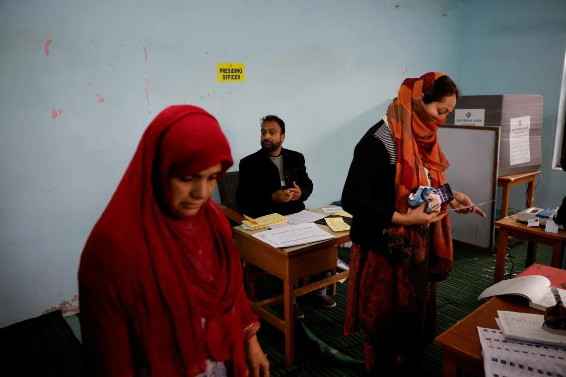 Election officers check the identity proof of voters at a polling station, during the fourth general election phase, in south Kashmir's Pulwama district, May 13, 2024. REUTERS/Sharafat Ali