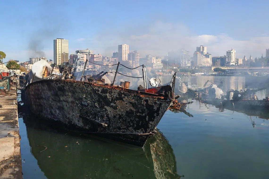 Smoke billowing from a Syrian naval ship destroyed in an overnight Israeli attack on the port city of Latakia on Dec 10, 2024. 