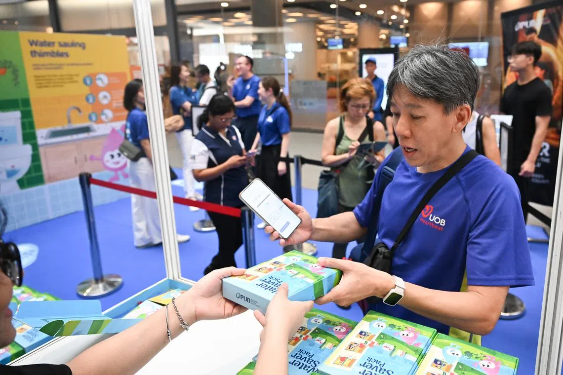 A member of the public receives a water saver pack at PUB’s annual Water Conservation Campaign held at Our Tampines Hub on March 8.