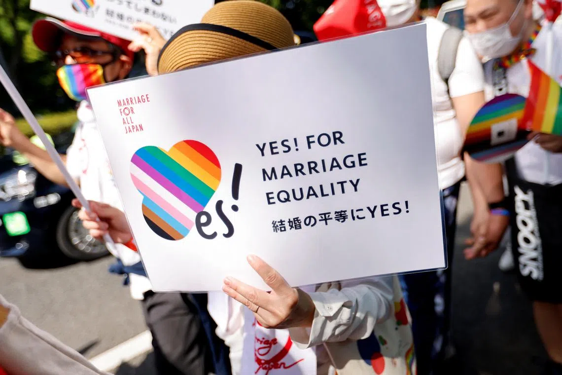 A participant holds a sign as they march during the Tokyo Rainbow Pride parade, celebrating advances in LGBTQ rights and calling for marriage equality, in Tokyo, Japan April 23, 2023. REUTERS/Issei Kato