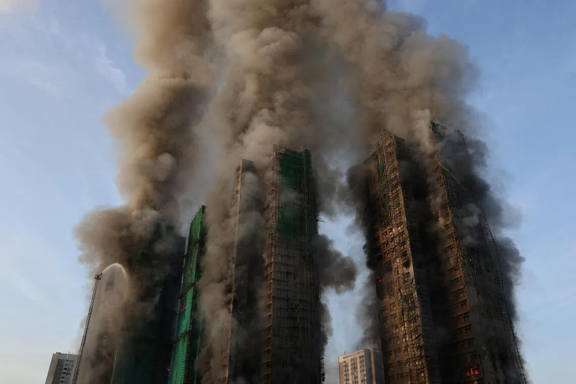 Smoke rises as flames engulf bamboo scaffolding across multiple buildings at Wang Fuk Court housing estate, in Tai Po, Hong Kong, China, November 26, 2025. REUTERS/Tyrone Siu
