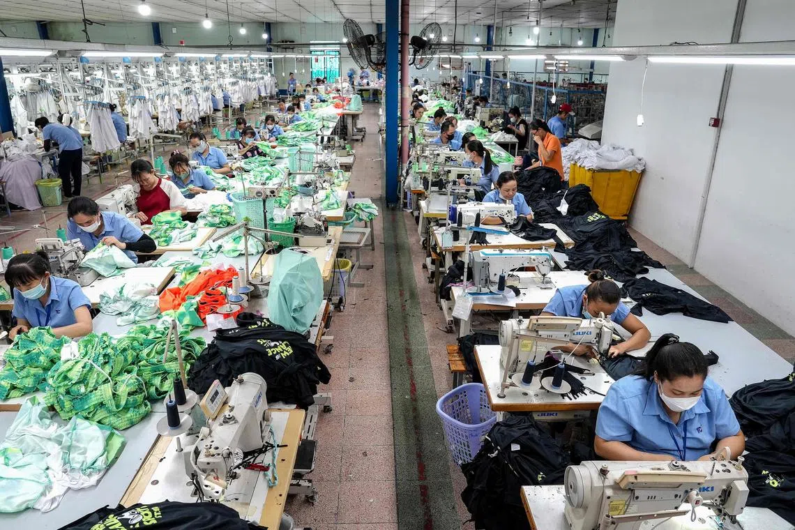 Vietnamese garment factory workers stitch apparel at a factory in Ho Chi Minh City on April 3.