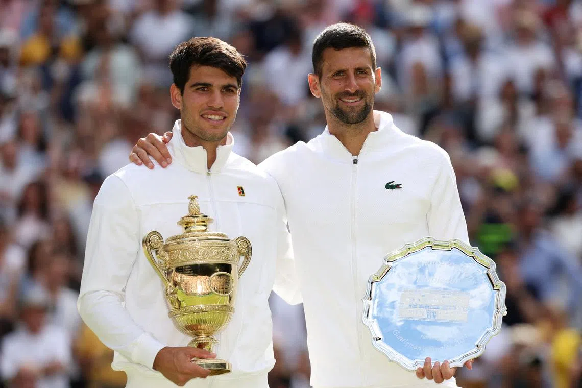 FILE PHOTO: Tennis - Wimbledon - All England Lawn Tennis and Croquet Club, London, Britain - July 14, 2024 Spain's Carlos Alcaraz and runner up Serbia's Novak Djokovic pose for a picture with their trophies after the men's singles final REUTERS/Paul Childs/File Photo