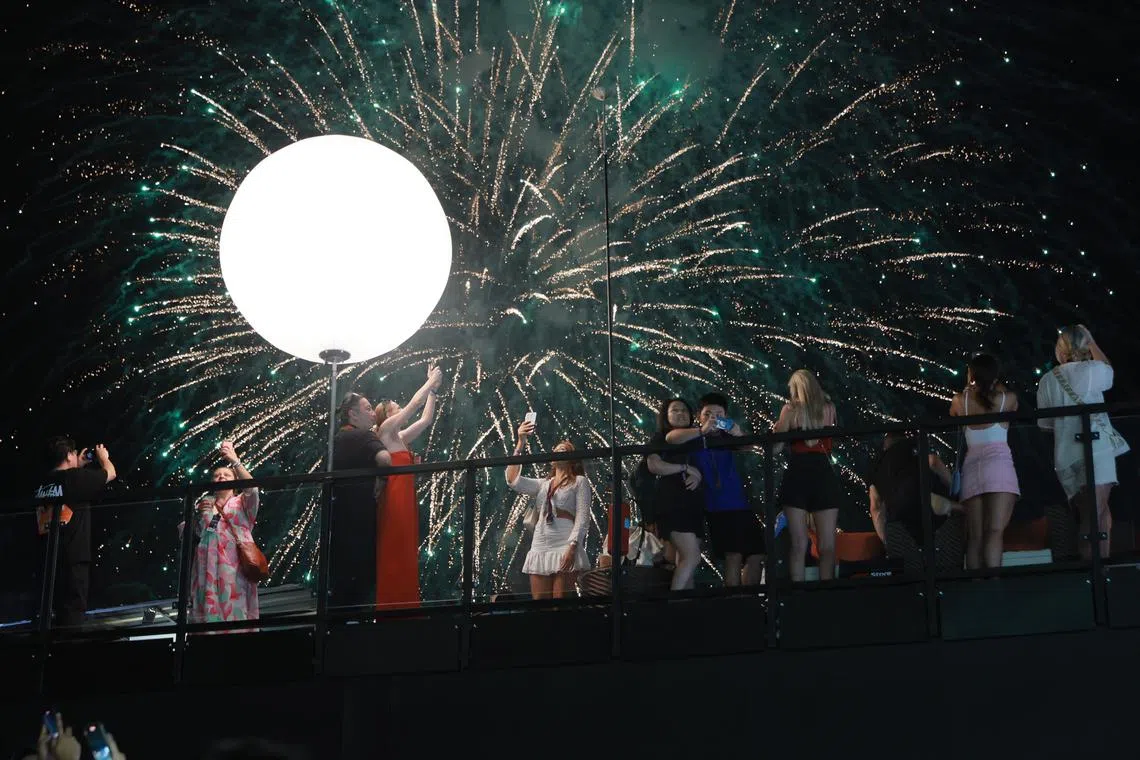 Spectators taking pictures of the fireworks from the grandstand at the Formula One Singapore Airlines Singapore Grand Prix at Marina Bay street circuit on Sept 17.