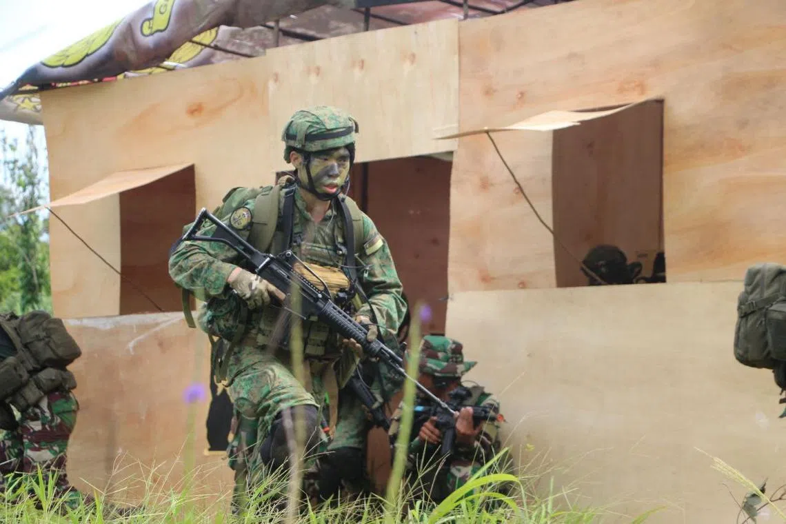 A commando from the Singapore Armed Forces advancing onto an objective alongside counterparts from Indonesia during Exercise Chandrapura.