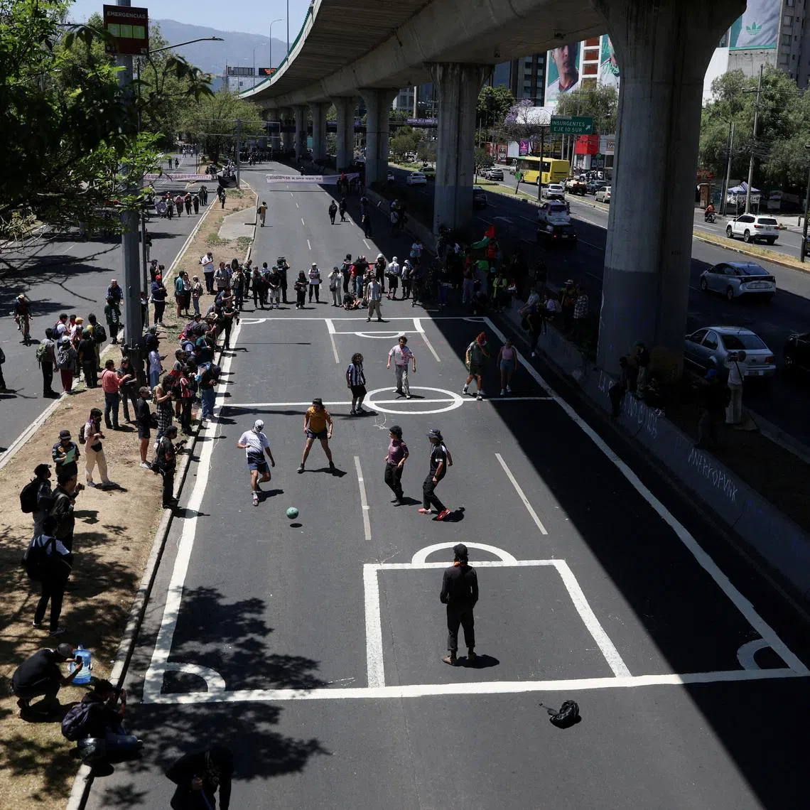 People from different civil organizations play soccer matches on a major urban highway to protest against the reopening of Azteca Stadium, officially renamed Banorte Stadium, on the day of a friendly match between the national teams of Mexico and Portugal held to mark the stadium's inauguration, as Mexico prepares for the 2026 FIFA World Cup co-hosted by the United States, Canada and Mexico, in Mexico City, Mexico, March 28, 2026. REUTERS/Luis Cortes