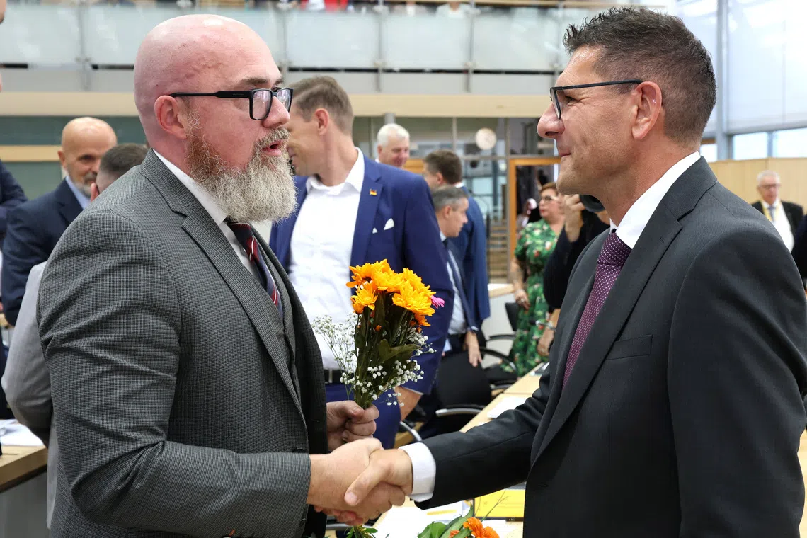 Thomas Schulze from the Buendnis Sahra Wagenknecht (Sahra Wagenknecht Alliance - BSW) congratulates Hans-Thomas Tillschneider from the far-right Alternative for Germany (AfD) party after he was elected vice-president of Saxony-Anhalt's state parliament,  during a session at the State Parliament in Magdeburg, Germany on October 6, 2026. Jan Woitas/Pool via REUTERS