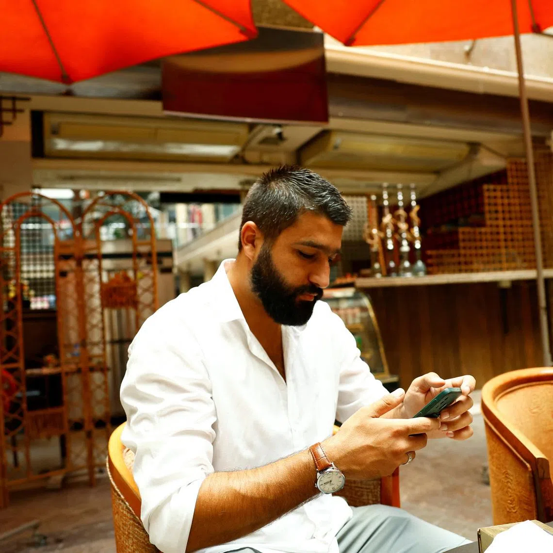 Khairallah Dib sits inside his coffee shop in Qurdaha, in the Latakia countryside, Syria, September 25, 2025. REUTERS/Yamam Al Shaar