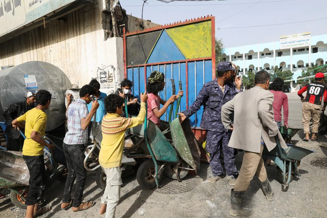 FILE PHOTO: Workers wait to ferry foodstuff outside an aid distribution center in Sanaa, Yemen September 28, 2022. REUTERS/Khaled Abdullah/File Photo