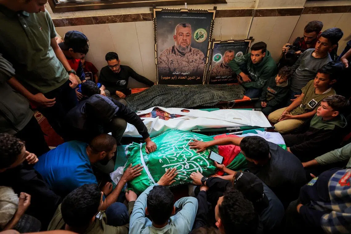 People gather around bodies identified by mourners as Hamas' military wing commander Izz al-Din al-Haddad, his wife and his daughter, who were killed in an Israeli strike on May 15.  