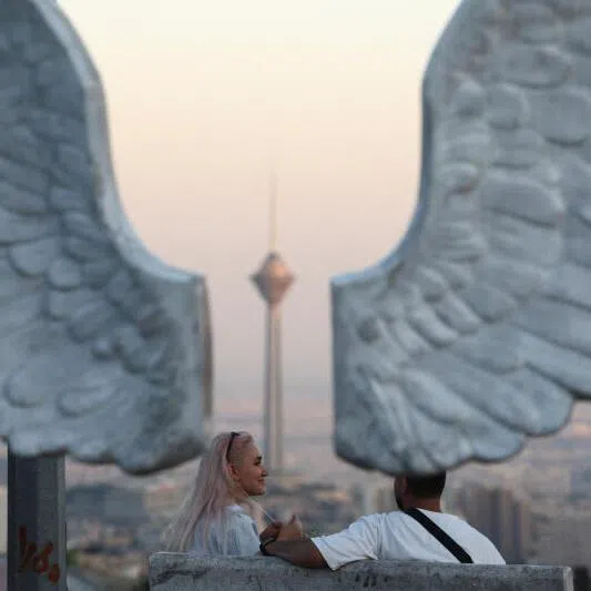 Iranian people in a park with a view of Milad Tower, in Tehran, Iran. A proposed $384.6 billion private fund to spur investment in Iran has secured commitments for more than half its target amount.
