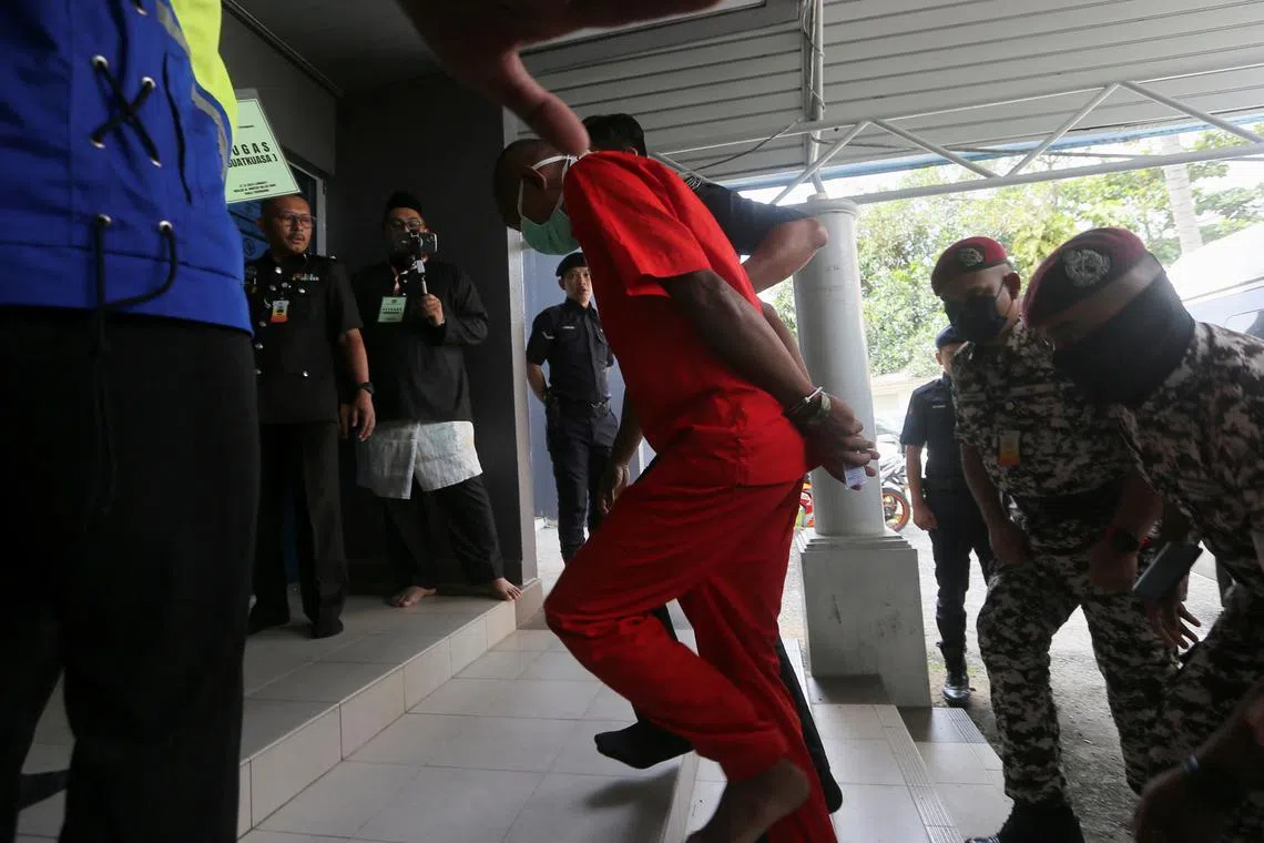 Mohd Affendi Awang, a 42-year-old father of five is escorted by a prison guard to face a public caning at a mosque, after being repeatedly convicted of the Islamic crime of 'khalwat', or close proximity between unmarried couples, at Kuala Terengganu, Malaysia December 27, 2024. REUTERS/Stringer