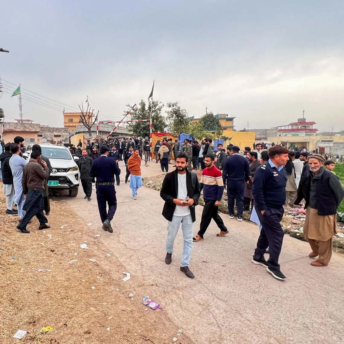 Pakistani paramilitary federal forces stand guard next to a crowd of people gathered near the site of a deadly explosion at a Shi'ite Muslim mosque in Islamabad, Pakistan, February 6, 2026. Picture taken with a phone. REUTERS/Salahuddin