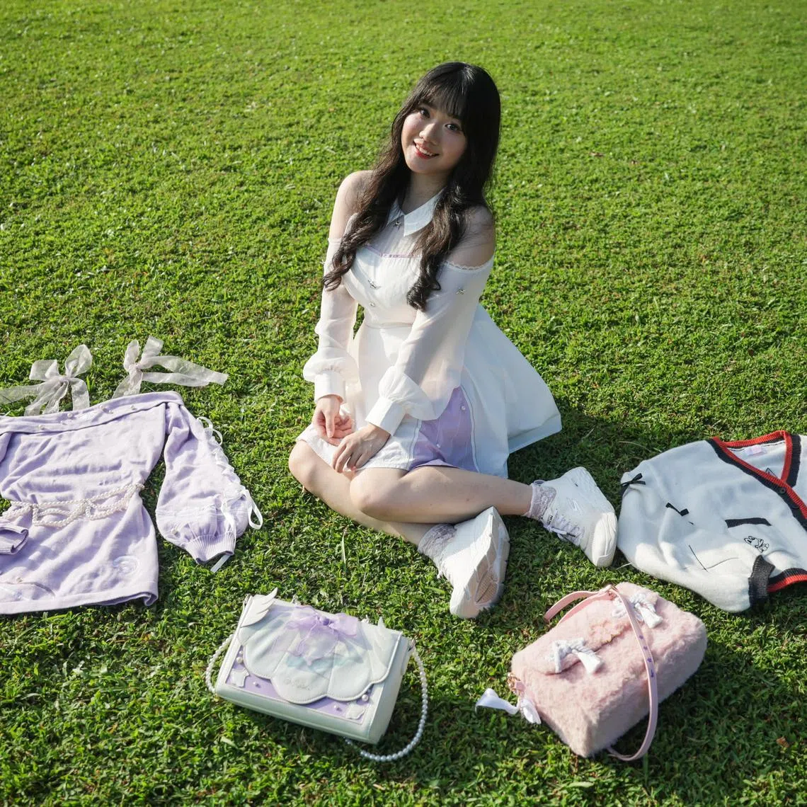 ST20250701_202549600219: Gin Tay/ cwhoyo/ Calista Wong/
Portraits of artist Astrea Lim mid-20s and her selection of self designed merchandise, photographed at Botanic Gardens on July 1, 2025.