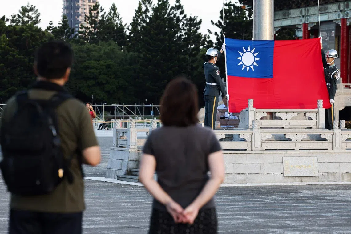 Guards raise Taiwan's national flag on the Democracy Boulevard at the Chiang Kai-shek Memorial Hall in Taipei on October 15, 2024. China insisted on October 14 it would never renounce the "use of force" to take control of Taiwan, after ending a day of military drills around the self-ruled island that Beijing said was a "stern warning" to "separatist" forces. (Photo by I-Hwa CHENG / AFP)
