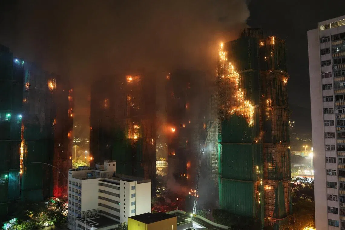 Firefighters work to extinguish flames, as fire burns bamboo scaffolding across multiple buildings at Wang Fuk Court housing estate, in Tai Po, Hong Kong, China, November 26, 2025. REUTERS/Tyrone Siu