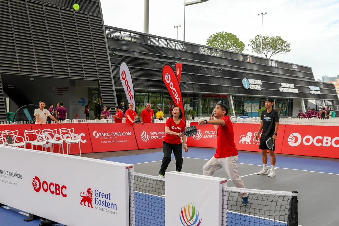 Helen Wong, group chief executive officer of OCBC (Left) and Jason Moo, chief executive officer of Bank of Singapore (Right) playing a game of Pickleball while Pickleball coach Koh Ruey Yi is coaching them from the back.
Taken at OCBC Square.
