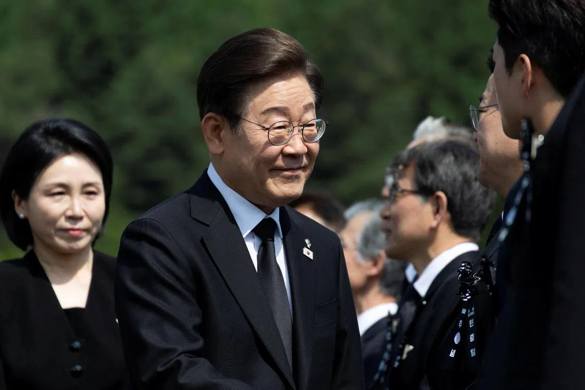 South Korean President Lee Jae-myung (C) and his wife Kim Hye-Kyung (L) arrive for a ceremony to mark the 70th Memorial Day at the Seoul National Cemetery in Seoul, South Korea, 06 June 2025. JEON HEON-KYUN/Pool via REUTERS