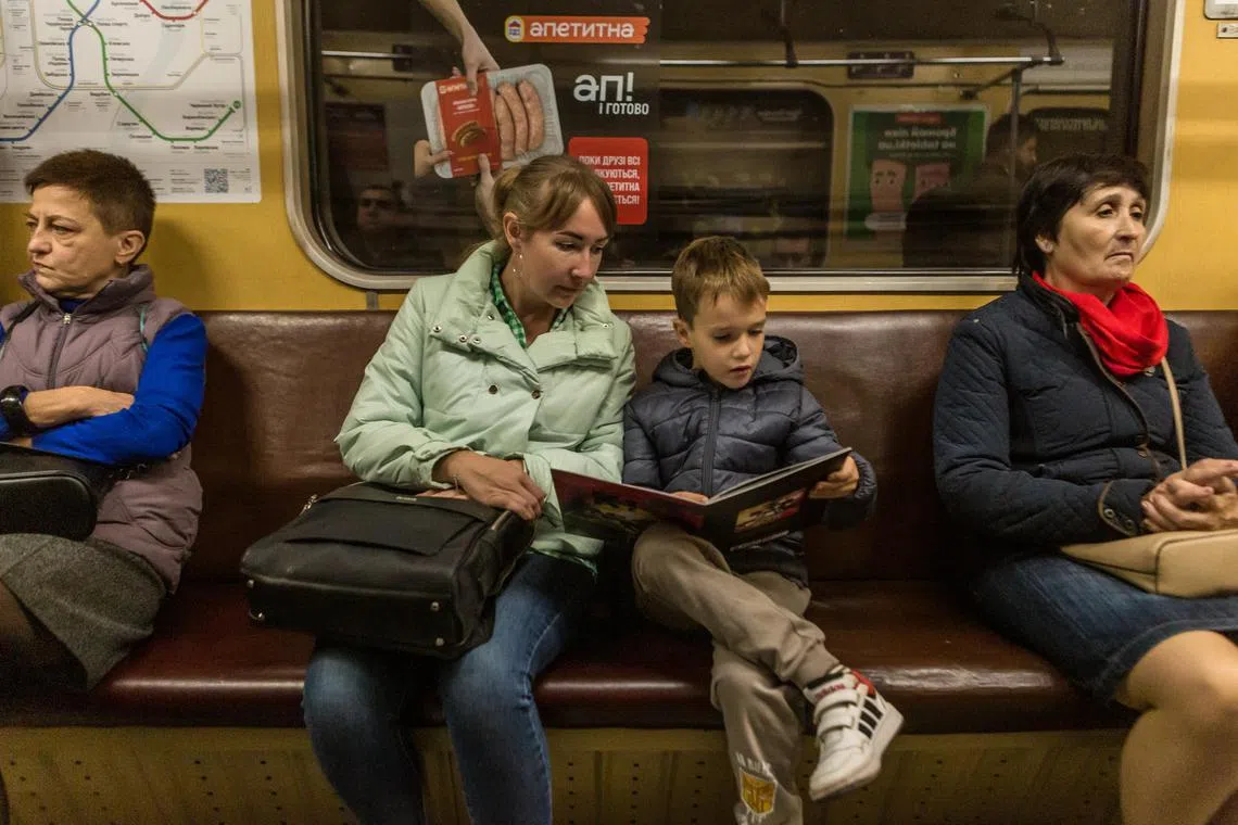 Ms Liudmyla Gurenchuk, a Ukrainian who with her young son Davyd, 7, has taken refuge from the war in France, take a subway to a medical appointment during a return visit to Kyiv, Ukraine, Oct. 30, 2023.  