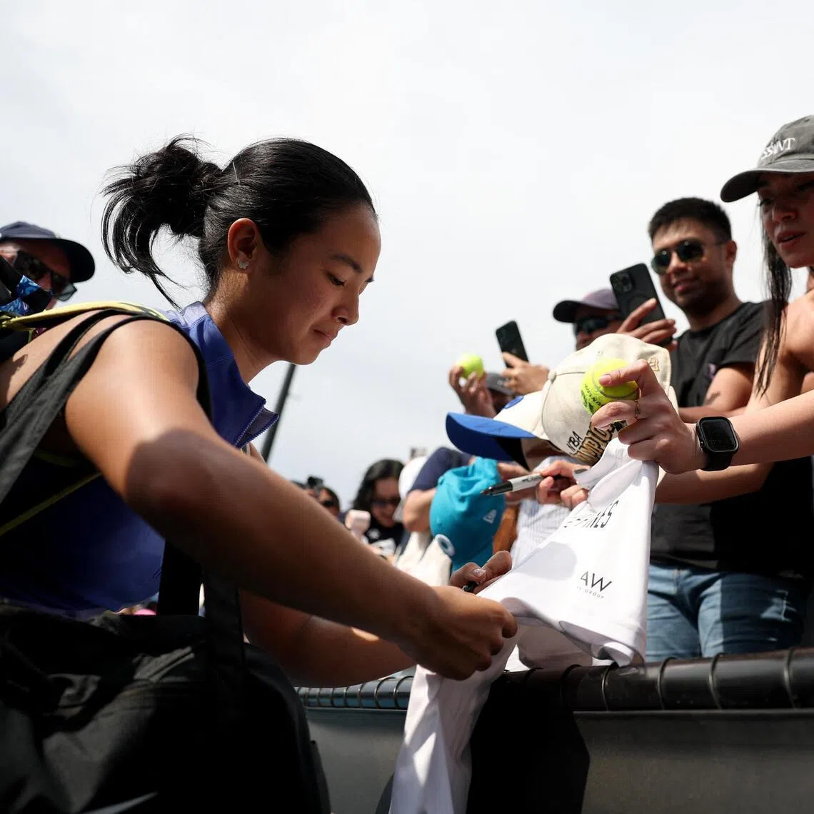 Even in defeat, Alexandra Eala of the Philippines stops to sign autographs for her legion of fans. 