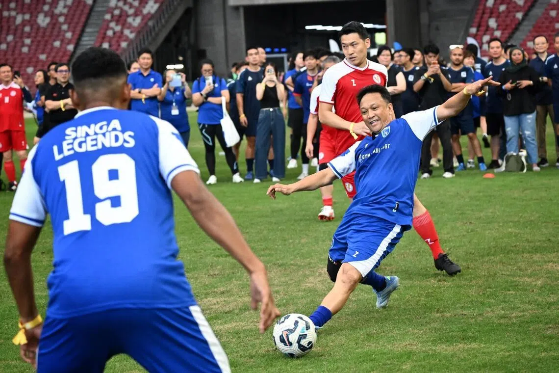 Team Singa Legend?s Fandi Ahmad (centre) passing the ball to his teammate Fazrul Nawaz (left) as Team Parliamentarian?s Acting MCCY Minister David Neo (background) defends during the Football With A Heart 2026 football match on April 25, 2026.