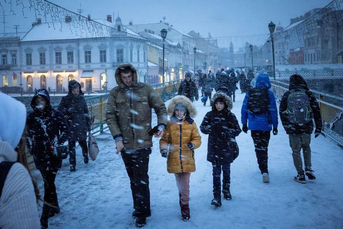 People walk on a snowy day in Uzhhorod which has a sizeable minority of ethnic Hungarians, amid Russia's attack on Ukraine, in Zakarpattia region, Ukraine November 30, 2023. REUTERS/Thomas Peter