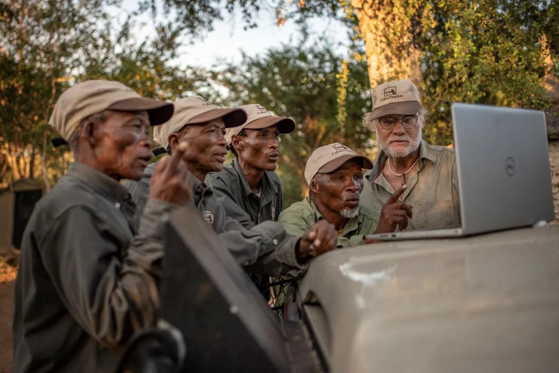 Indigenous animal trackers and Louis Liebenberg look at CyberTracker dashboard