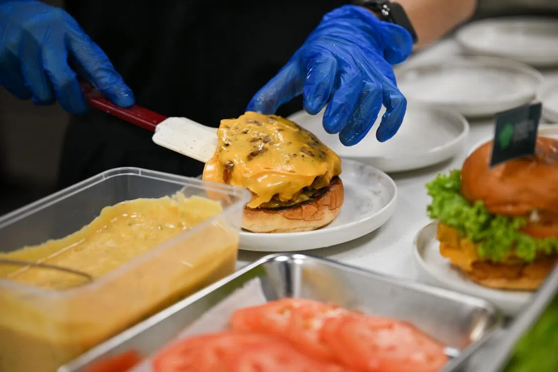 Burgers being assembled with Q Protein’s beef patty with cheese at Nurasa.