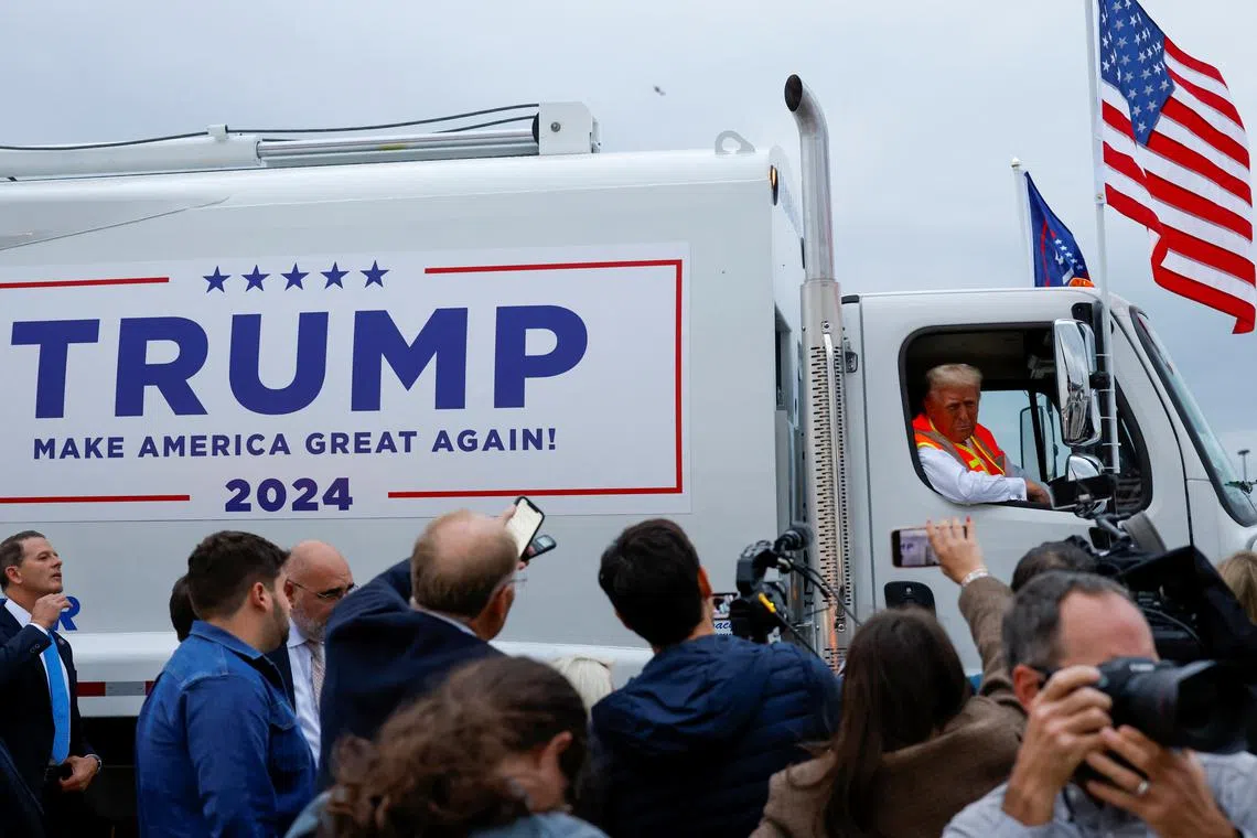 Donald Trump donned an orange reflective safety vest and climbed into the passenger seat of a garbage truck in Green Bay, Wisconsin, on Oct 30.