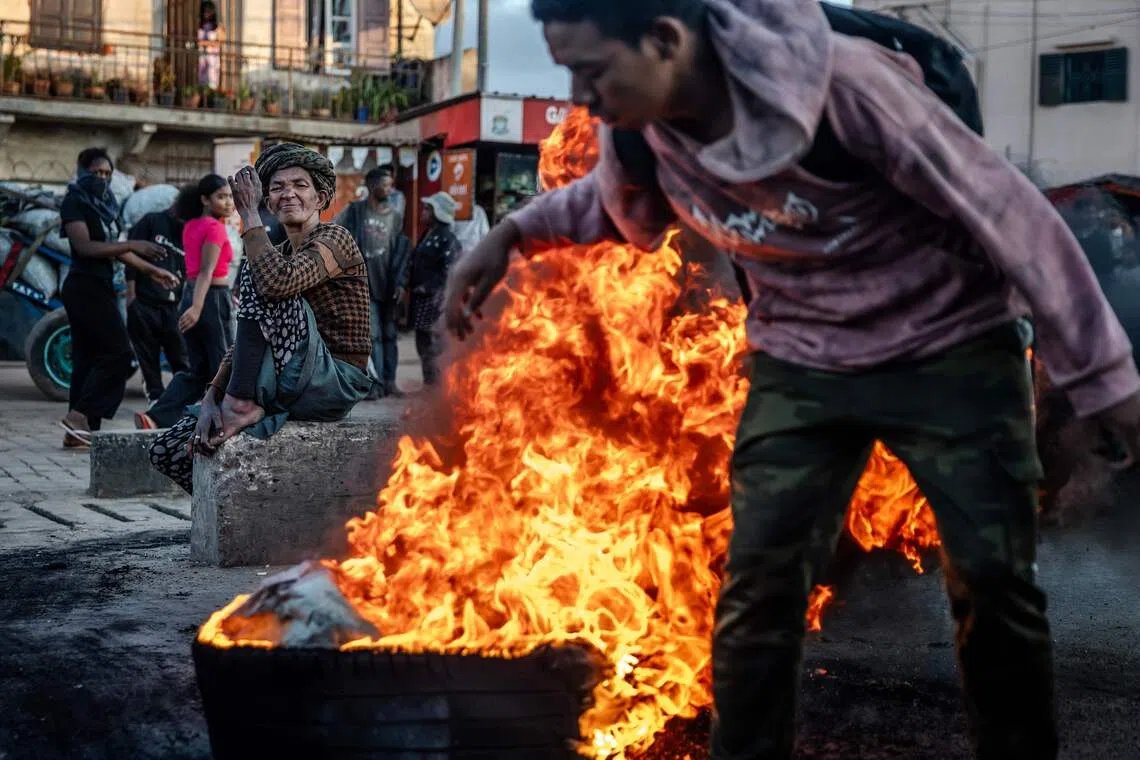 A bystander watching as students burn tyres as barricades during clashes between protesters and Malagasy security forces at a demonstration demanding the resignation of President Andry Rajoelina, in Antananarivo, on Oct 6, 2025. 