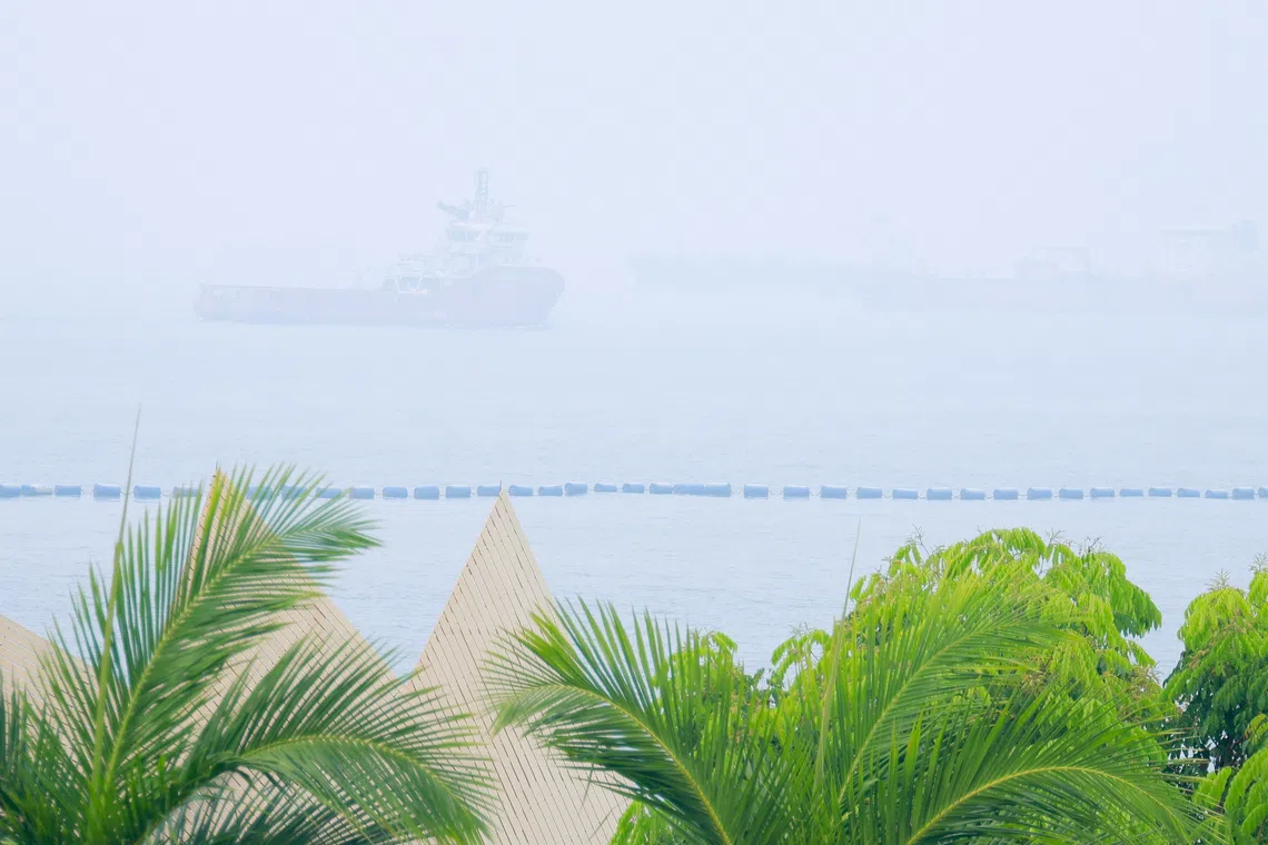 Ships sail in hazy conditions in the waters off Siloso Beach on Oct 14.