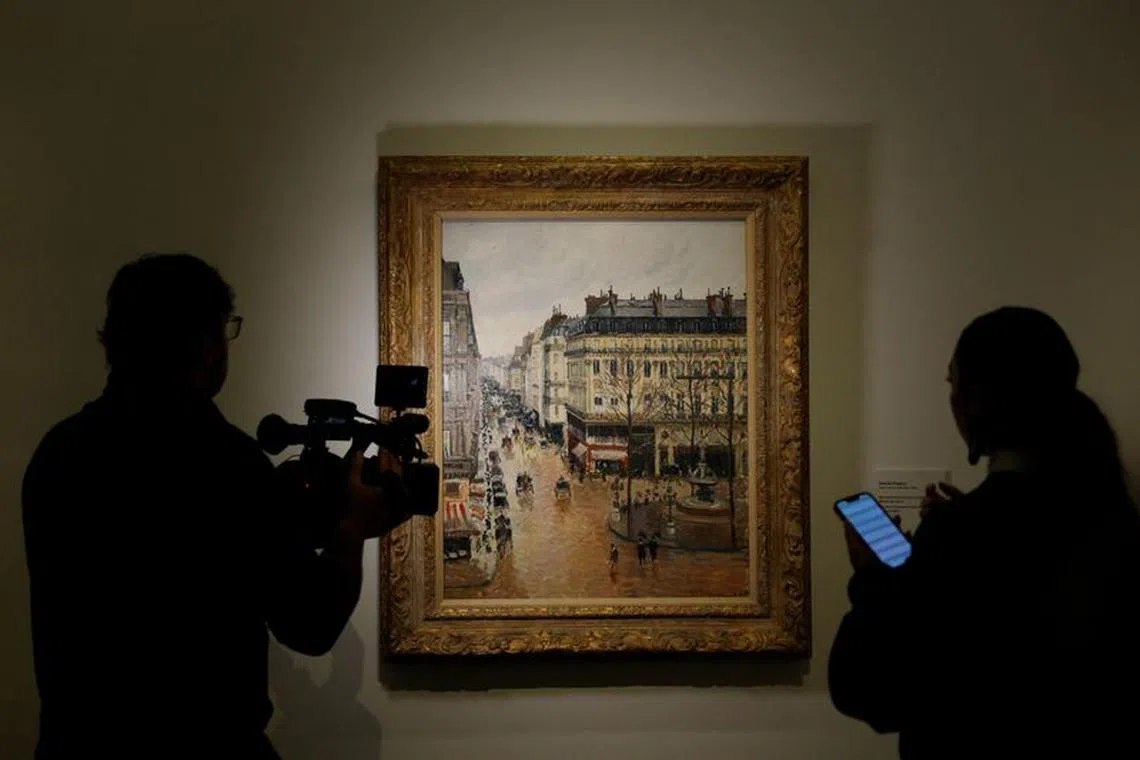 Members of the media stand by Camille Pissarro's 1897 \"Rue Saint-Honore in the Afternoon. Effect of Rain\" at Thyssen-Bornemisza museum in Madrid, Spain, January 10, 2024. REUTERS/Susana Vera