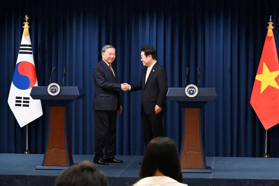 South Korean President Lee Jae Myung (right) shakes hands with Vietnamese leader To Lam at the presidential office in Seoul, South Korea. 