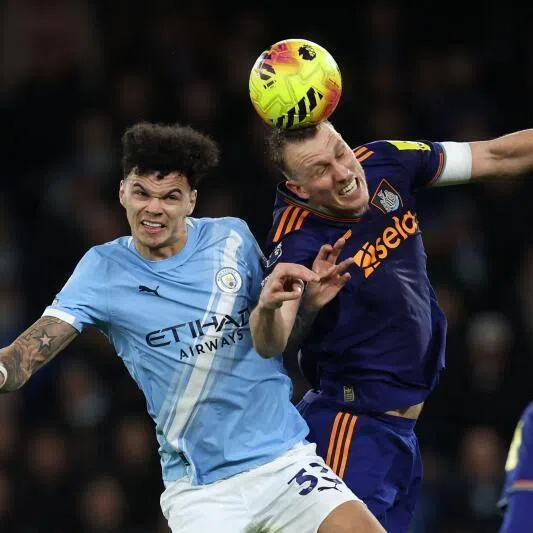 Manchester City's English midfielder Nico O'Reilly (left) vies with Newcastle United's English defender Dan Burn during the match.