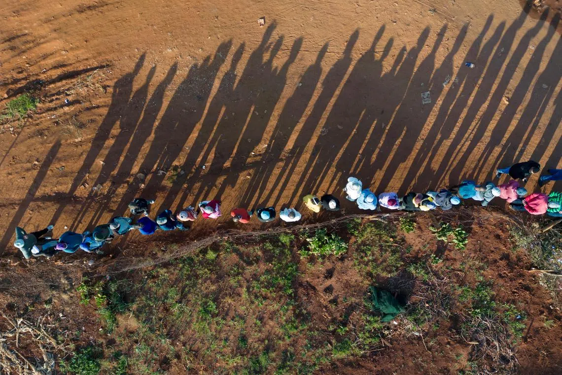 FILE PHOTO: A drone view shows people queue at the Hospital Hill township to vote during the South African elections, in Johannesburg, South Africa May 29, 2024. REUTERS/Ihsaan Haffejee/File Photo