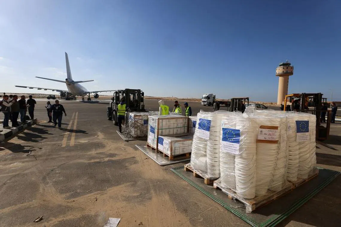 FILE PHOTO: Workers stand next to the European Union's humanitarian aid destined for the Gaza Strip via Rafah border area, during a temporary truce between Palestinian Islamist group Hamas and Israel, at Al Arish airport, in Al Arish, Egypt, November 30, 2023. REUTERS/Mohamed Abd El Ghany/File Photo